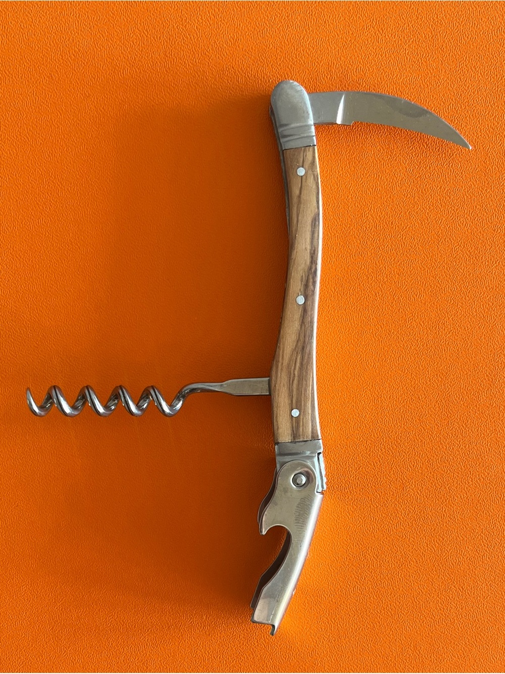 Laguiole sommelier corkscrew with a polished metal bolster and a warm wood grain